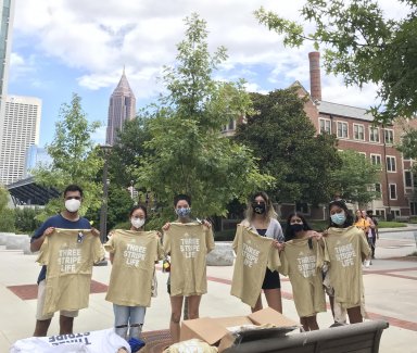 Mihir Kandarpa, vice president of Well-being for Undergrduate SGA (left) shares surprise swag with those participating in weekly asymptomatic surveillance testing at Georgia Tech.