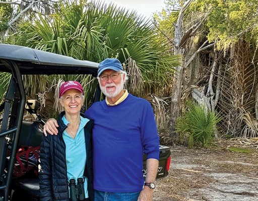 President Emeritus G. Wayne Clough and his wife, Mara Loftman, standing in front of subtropical vegetation including palm trees near the Georgia coast.